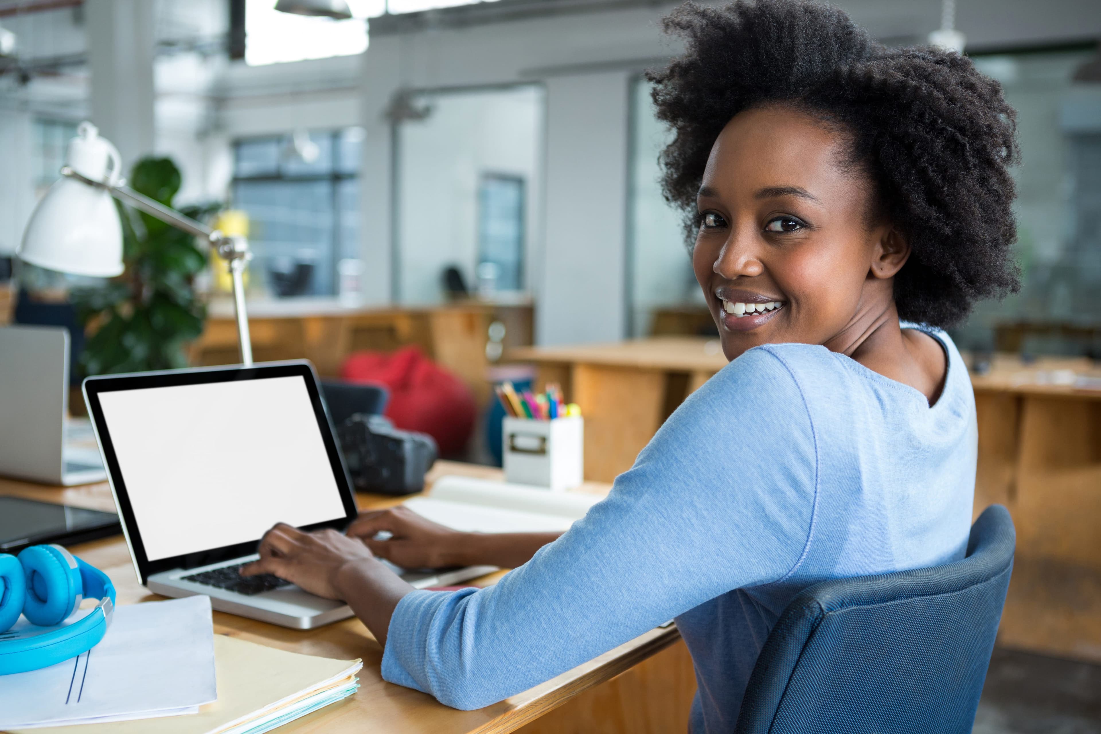 Student browsing courses on a laptop in a modern office